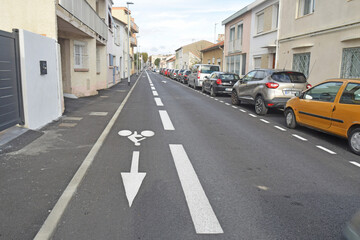 Signalisation au sol, rue à sens unique pour les voitures avec contresens pour les vélos. - obrazy, fototapety, plakaty