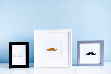 Different color male moustaches in the photo frames on the blue background. Men health awareness month, fathers day masculinity concept. Male Diversity. Face hair Fashion. Selective focus, Copy space.