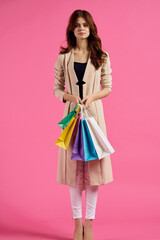 cheerful woman with packages in hands Shopaholic pink background