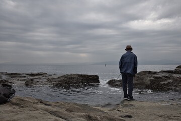 磯で釣りをする男性