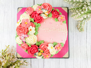 Beautiful homemade cake. Cake decorated with red and pink rose and flora with butterfly for birthday.
