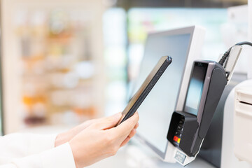セルフレジ・電子マネー決済をする若い女性