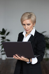 business woman stands with laptop in the office