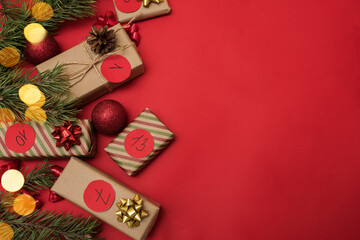 Boxes in kraft paper for the Advent calendar on a red background, Christmas gifts with the dates of the advent calendar top view, place for text.