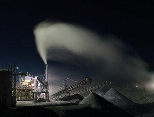 Panorama of working stone crushing machine at night at the mining factory, long exposure. Quarry...