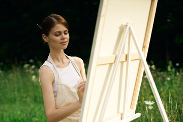 woman artist paints a picture near easel outdoors landscape creative