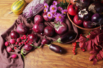 Eggplants, red onions and other vegetables on a wooden table. 