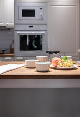 Part of the kitchen interior with utensils and fruits on the table.