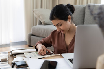 Indian female architect interior designer choose ceramic tiles samples sit at home work remotely....