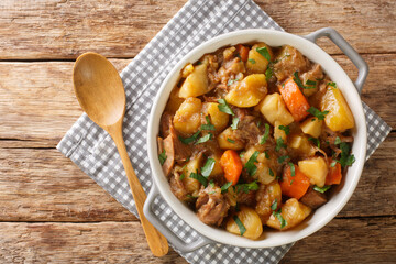 Scottish Stovies traditional Comfort Food with potatoes, meat and other vegetables close up in the pot on the table. Horizontal top view from above