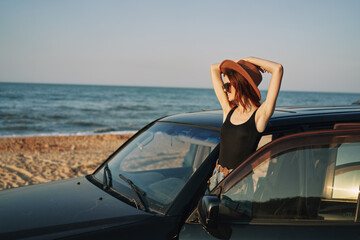 woman on the beach is with a car wearing sunglasses travel