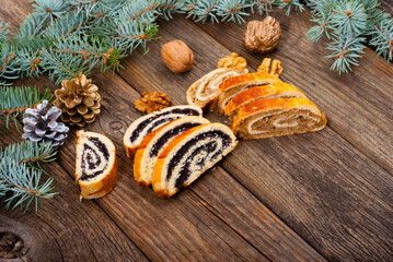 poppy and walnut roll cakes, pine branch, old wood table