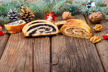 poppy and walnut roll cakes, santa and angel decorations, pine branch garland, old wood table