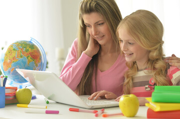 Mother and daughter with laptop at home
