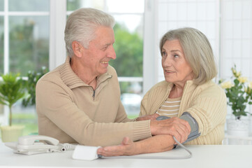 senior couple measuring blood pressure together