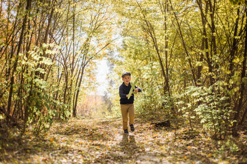 Fototapeta premium Young boy play with toy airplaine in hands. Happy Kid is playing in park outdoors