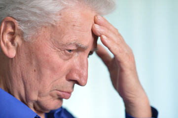 Fototapeta premium Portrait of sad sick senior man with headache