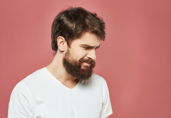 Fototapeta premium bearded man in a white t-shirt expressive look discontent pink background