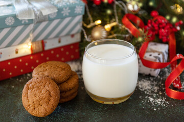 Holiday concept, Christmas morning. Homemade Cookies and milk for Santa Clause near the Christmas tree with present.
