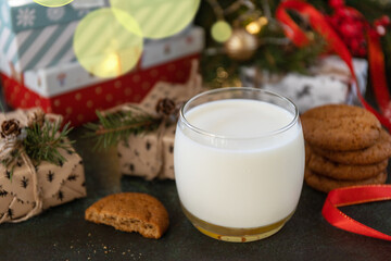 Holiday concept, Christmas morning. Homemade Cookies and milk for Santa Clause near the Christmas tree with present.