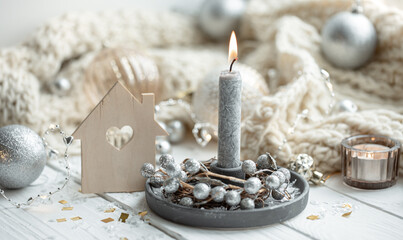 Cozy winter background with burning candle and festive decor details.