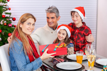 Happy smiling caucasian family at home for Christmas unwrapping Christmas presents