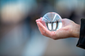 Male hand holding a transparent ball with Brooklyn Bridge reflec