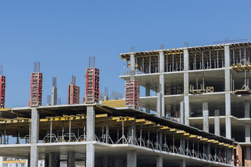 Construction of a multi-storey apartment building are work along the building in progress