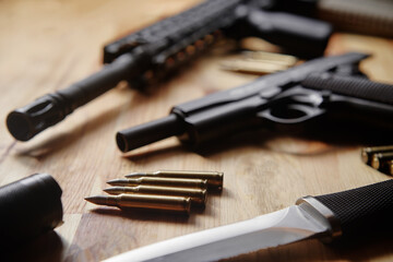 Weapons and military equipment for army, Assault rifle gun, handgun and knife on wooden background.