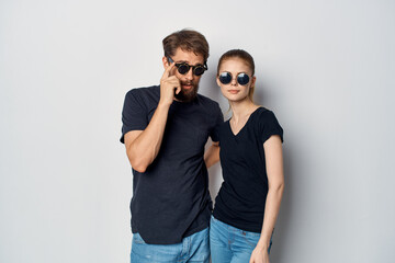 fashionable man and woman friendship communication romance wearing sunglasses light background