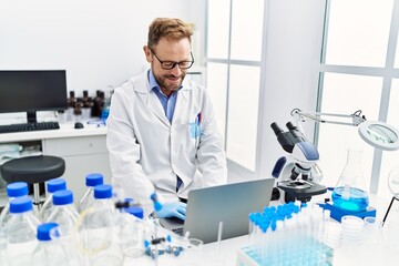 Middle age hispanic man wearing scientist uniform working at laboratory