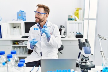 Fototapeta premium Middle age hispanic man wearing scientist uniform working at laboratory