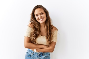 Beautiful hispanic woman standing over isolated while background happy face smiling with crossed arms looking at the camera. positive person.