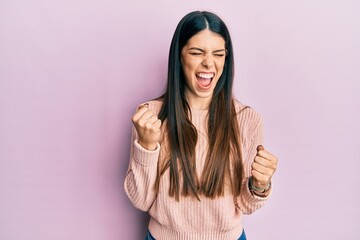 Young hispanic woman wearing casual clothes celebrating surprised and amazed for success with arms raised and eyes closed