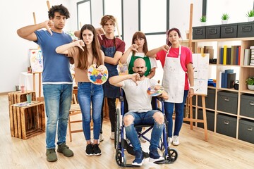 Group of young artists people at art studio with angry face, negative sign showing dislike with thumbs down, rejection concept