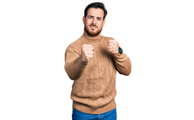 Young hispanic man wearing casual clothes ready to fight with fist defense gesture, angry and upset...