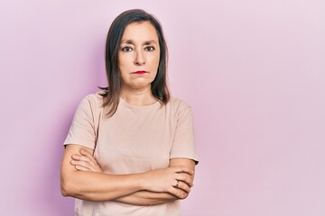 Fototapeta premium Middle age hispanic woman with arms crossed gesture relaxed with serious expression on face. simple and natural looking at the camera.