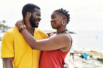 Young african american couple smiling happy and hugging at the beach.
