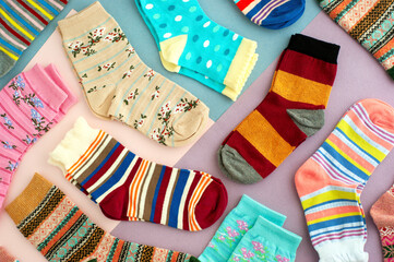 Colorful socks on a multicolored background. Many different socks for fall and winter. Knitted...