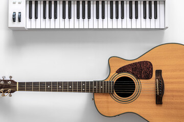 Acoustic guitar and musical keys on a white background, flat lay.