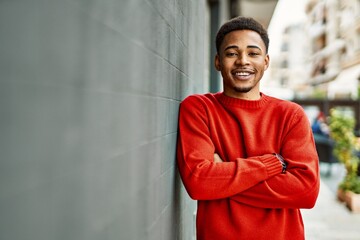 Handsome african american man outdoors standing over gray wall