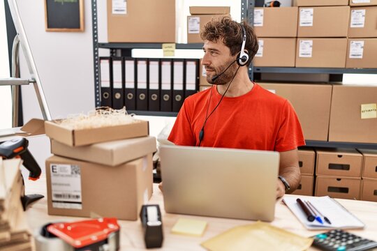 Young Hispanic Call Center Agent Man Working At Warehouse Looking To Side, Relax Profile Pose With Natural Face And Confident Smile.