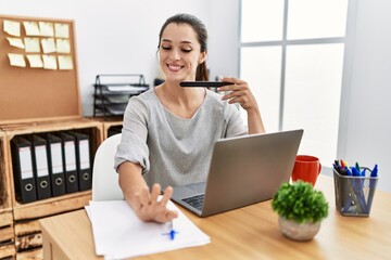 Young hispanic woman using lime nails working at office