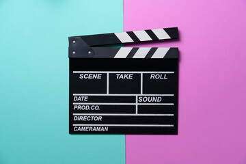 Fototapeta na wymiar movie clapper on green and pink table background ; film, cinema and video photography concept