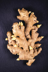Ginger root on a black stone background.