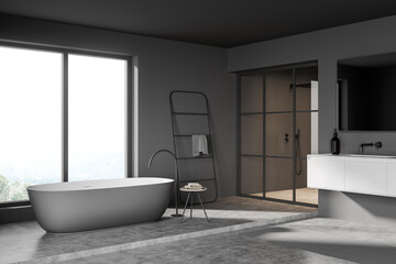 Dark bathroom interior with bathtub and window, sink and shower