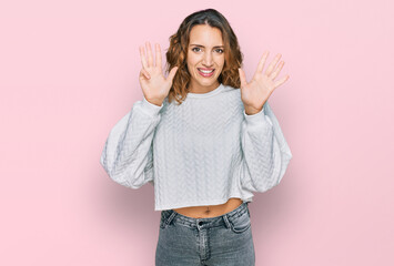 Beautiful young caucasian woman wearing casual winter sweater showing and pointing up with fingers...