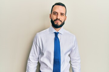 Young man with beard wearing business tie relaxed with serious expression on face. simple and natural looking at the camera.