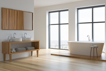 Bathroom interior with two sinks and mirror, bathtub near window