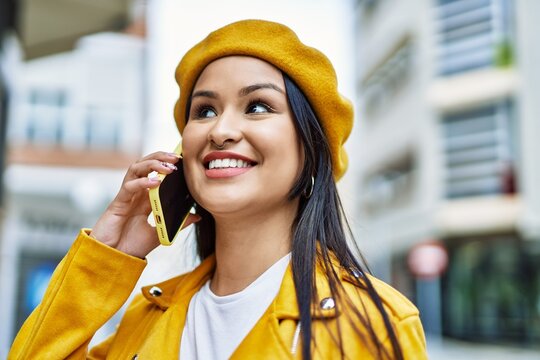 Young latin girl smiling happy talking on the smartphone at the city.